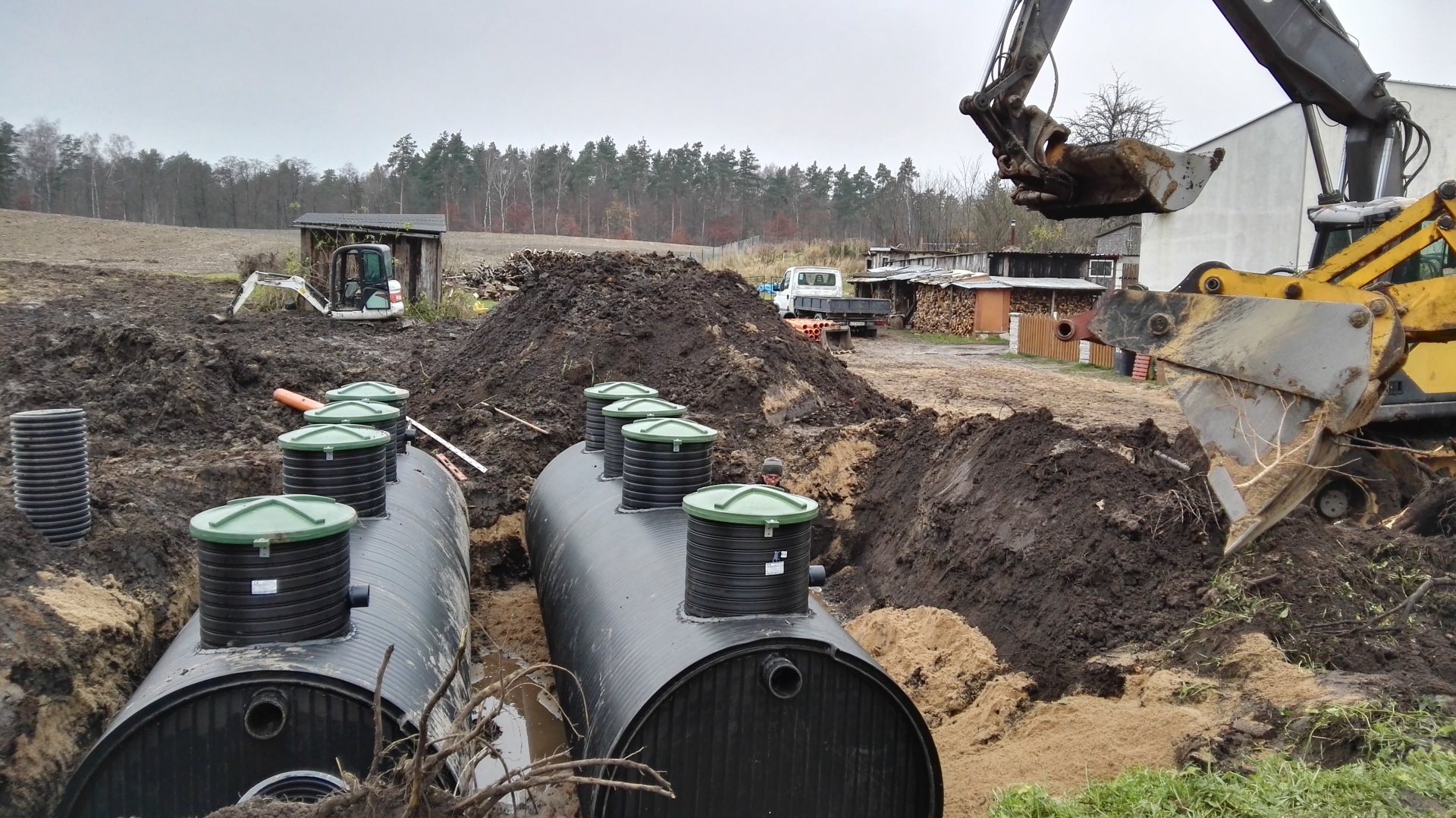 Budowa oczyszczalni ścieków gminie Liniewo; na zdjęciu widać zbiorniki w rowie, obok koparka