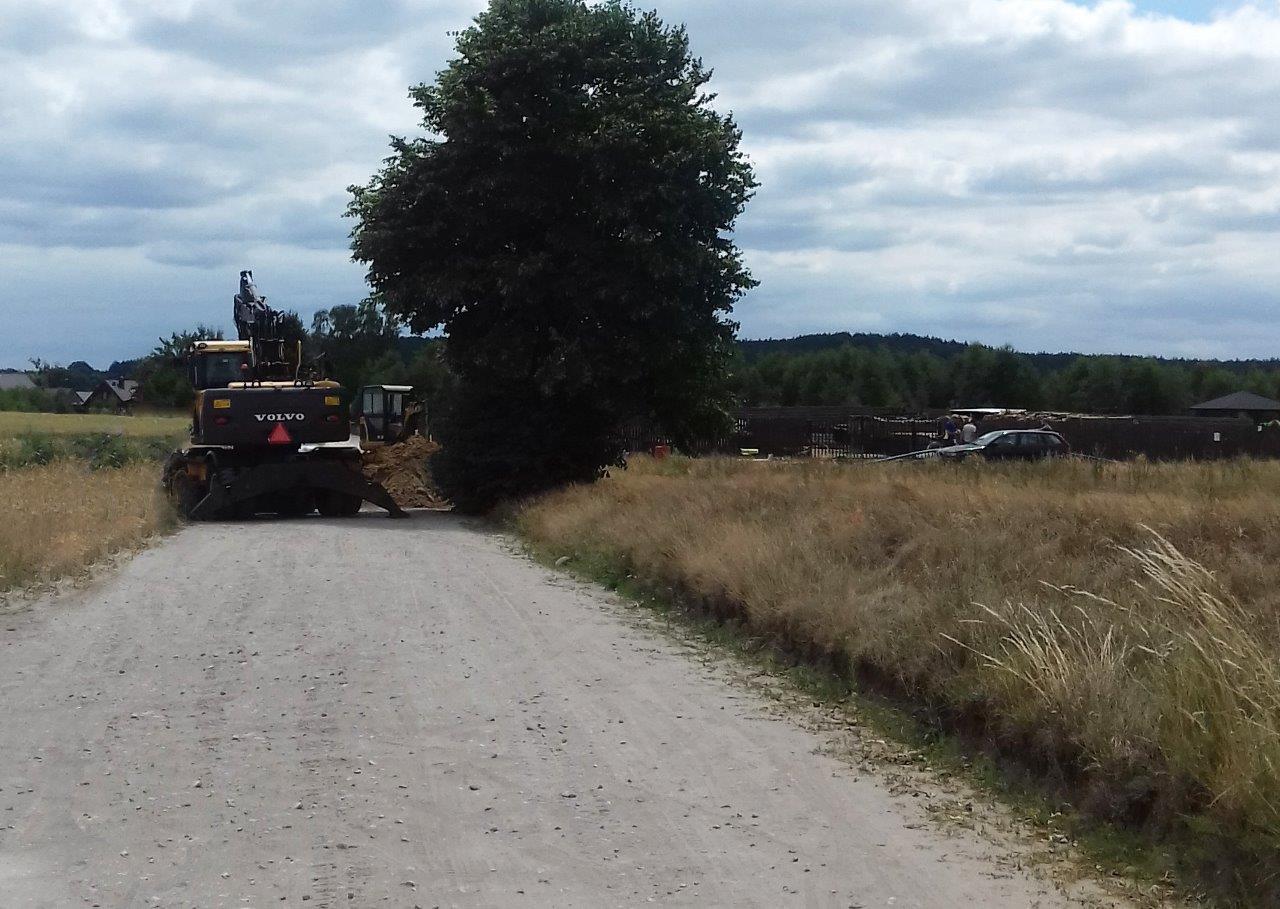 Budowa sieci wodno – kanalizacyjnej w Wielu, na zdjęciu widać drogę, w tle koparki, zwały ziemi