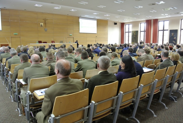 Sala Wyższej Szkoły Kultury Społecznej i Medialnej w Toruniu wypełniona uczestnikami konferencji, w tle – prelegent spotkania