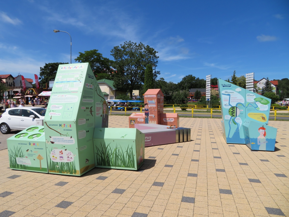 Trzy bryły interaktywnej wystawy plenerowej na placu w Krynicy Morskiej