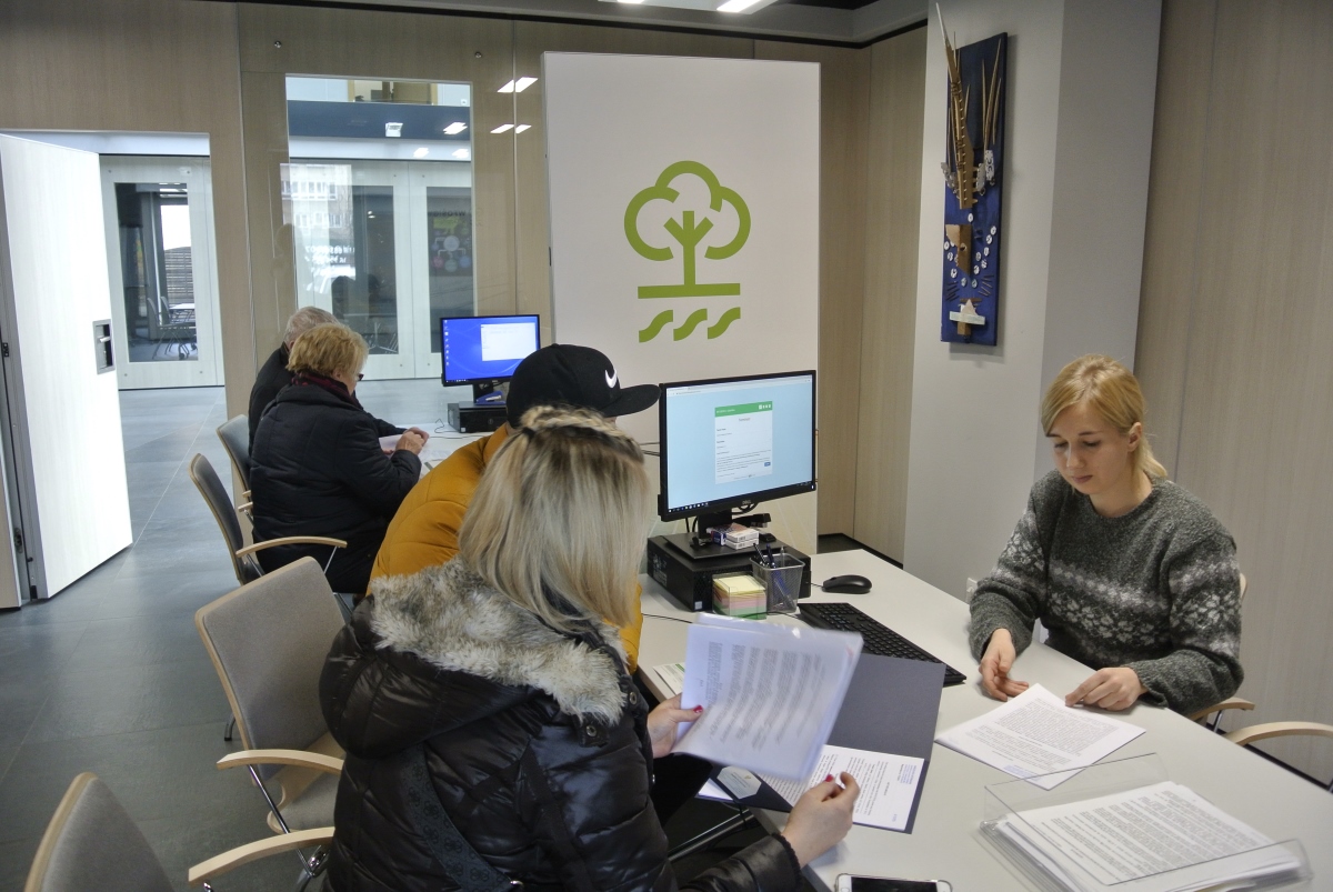 Punkt konsultacyjny "Czystego Powietrza" w WFOŚiGW w Gdańsku, przy stole siedzi pracownik Funduszu oraz wnioskodawcy