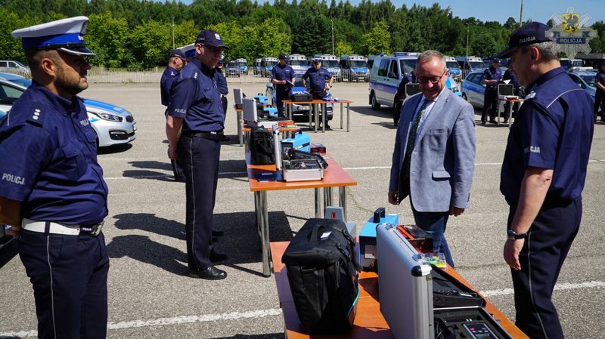 Uroczystość przekazania specjalistycznego sprzętu 9 jednostkom pomorskiej policji. Na zdjęciu widać prezesa WFOŚiGW w Gdańsku oglądającego sprzęt, dookoła stoją umundurowani policjanci