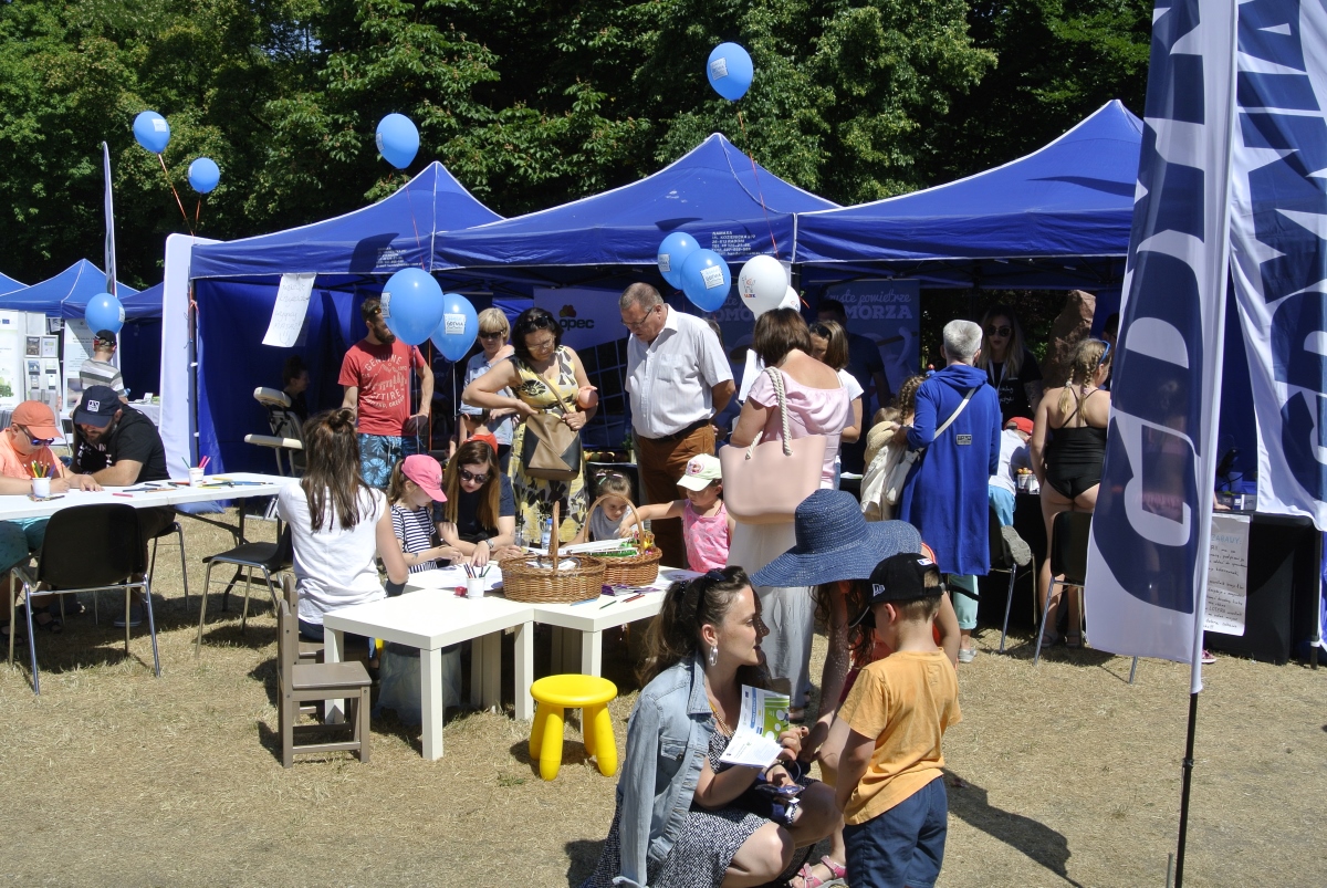 Pomorski Piknik Energetyczny w 2018 roku, przed namiotami stoi dużo dzieci, młodzieży i dorosłych