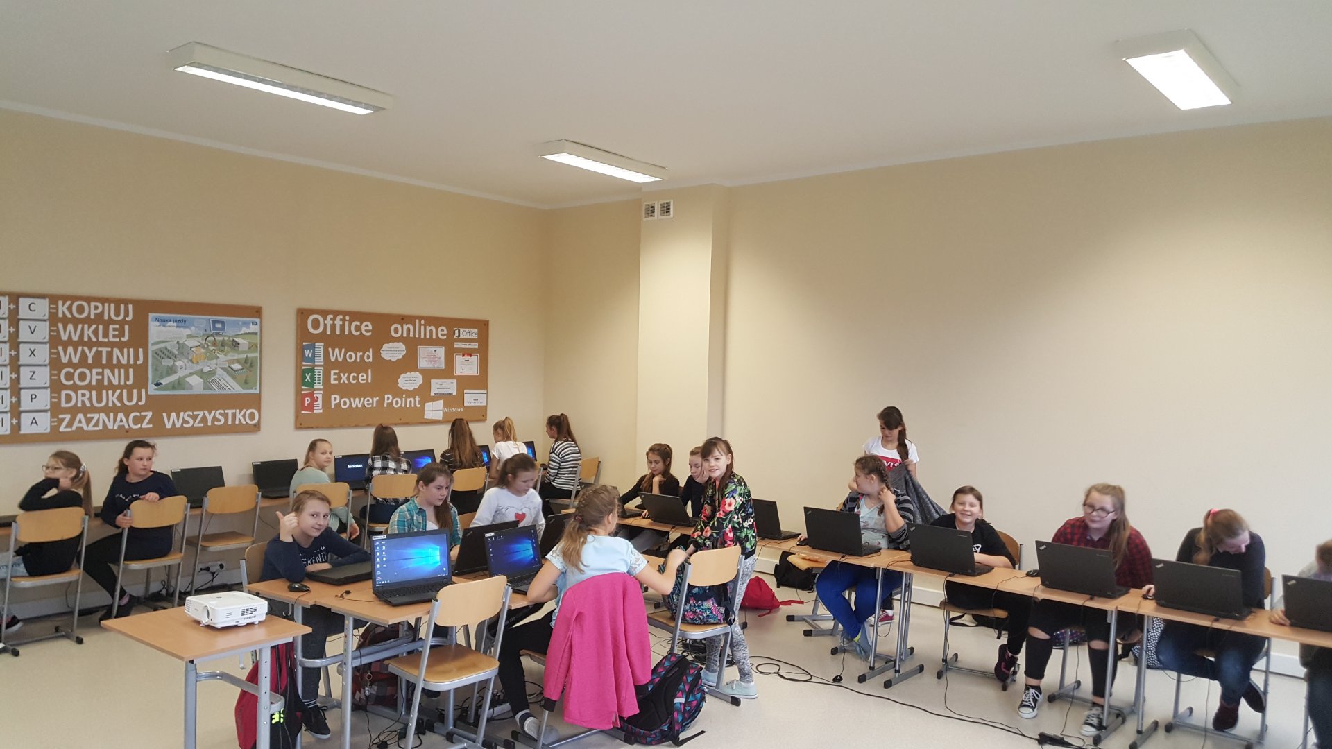 Klasa szkolna podczas zajęć, na suficie zamontowane zostało nowoczesne oświetlenie typu LED