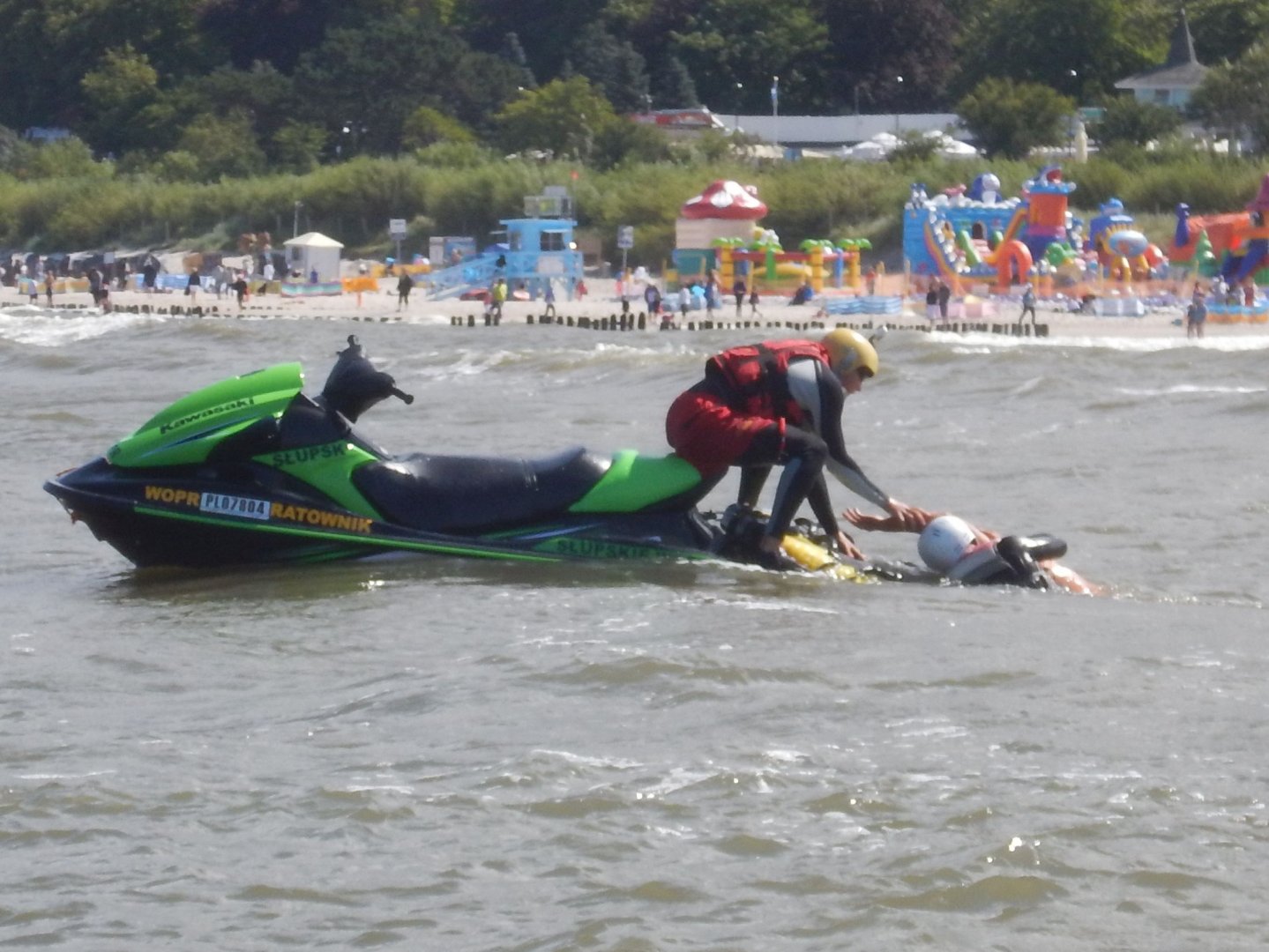 Skuter na wodach Morza Bałtyckiego, ratownik pomaga wyjść z wody osobie poszkodowanej