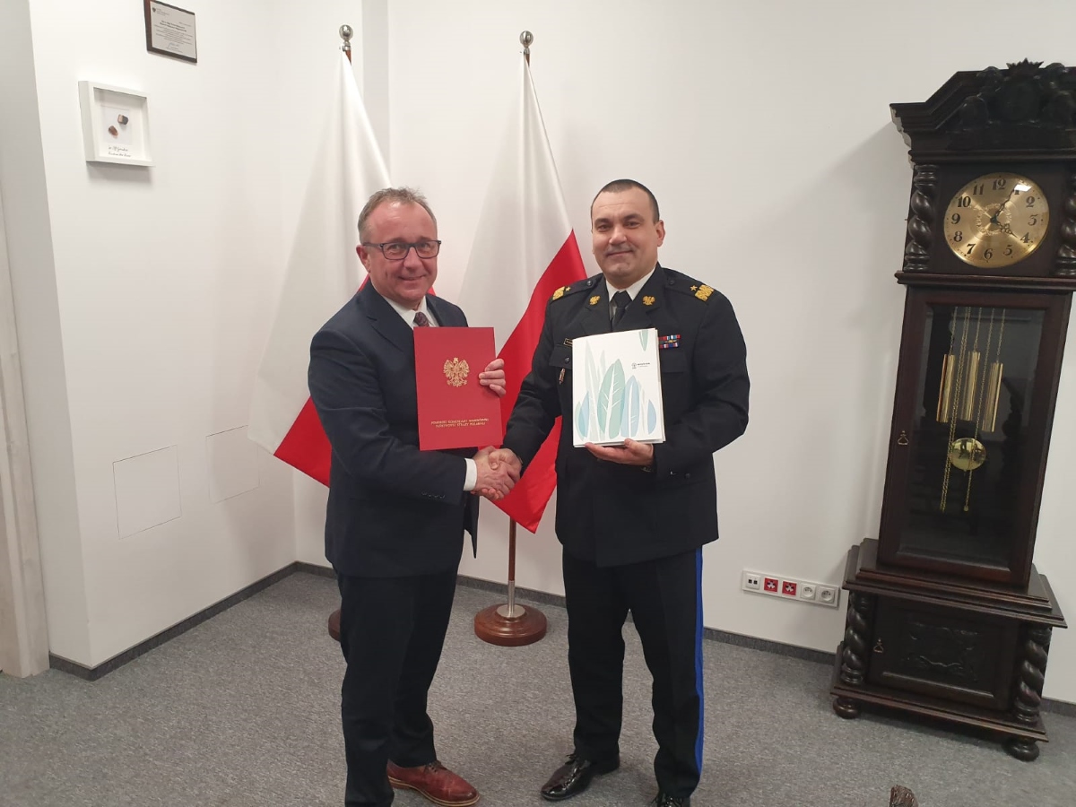 Sygnatariusze listu intencyjnego: prezes WFOŚiGW w Gdańsku Maciej Kazienko oraz nadbryg. Tomasz Komoszyński – pomorski komendant wojewódzki PSP; mężczyźni trzymają w rękach teczki z listem intencyjnym, za nimi stoi flaga narodowa 