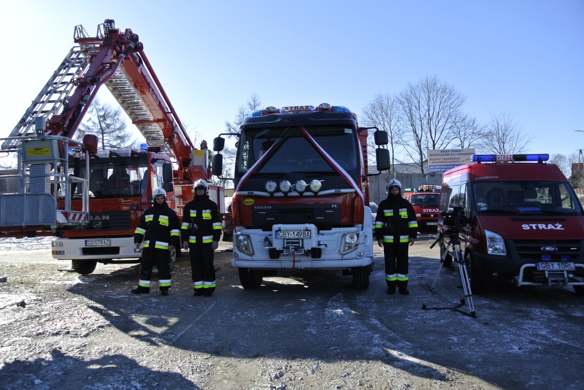 Nowy samochód ratowniczo-gaśniczy dla OSP Parchowo; w pobliżu stoją strażacy, obok nich dwa inne samochody wykorzystywane przez strażaków