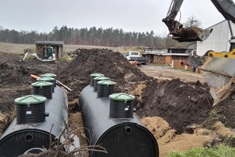 Budowa oczyszczalni ścieków gminie Liniewo; na zdjęciu widać zbiorniki w rowie, obok koparka