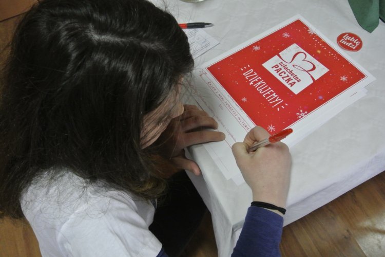 Wolontariuszka Szlachetnej Paczki wypisuje podziękowania dla WFOŚiGW w Gdańsku