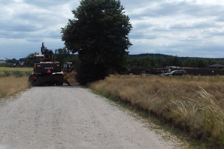 Budowa sieci wodno – kanalizacyjnej w Wielu, na zdjęciu widać drogę, w tle koparki, zwały ziemi