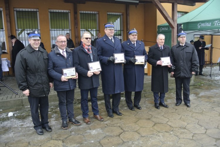 Uroczystość przekazania pojazdów i sprzętu ratowniczo-gaśniczego, na zdjęciu stoi siedmiu mężczyzn: Roman Jankowski – naczelnik OSP Swarożyn, Maciej Kazienko – prezes WFOŚiGW w Gdańsku, Krzysztof Augustyniak – wójt gminy Tczew, bryg. Andrzej Mróz – komendant powiatowy PSP w Tczewie, bryg. Dariusz Żywicki – zastępca komendanta wojewódzkiego PSP w Gdańsku, Dariusz Drelich - wojewoda pomorski, Łukasz Kuśmierczyk – prezes OSP Swarożyn zdj. WFOŚiGW w Gdańsku