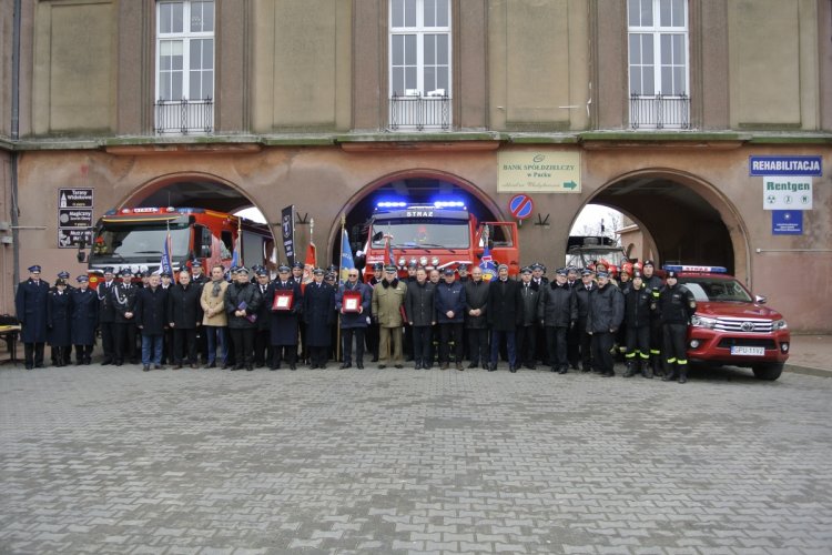 W szeregu przed samochodami pożarniczymi stoją uczestnicy uroczystości
