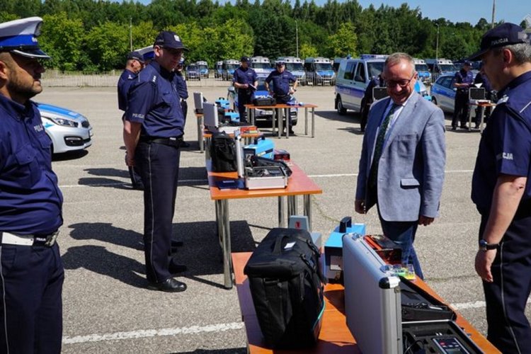 Uroczystość przekazania specjalistycznego sprzętu 9 jednostkom pomorskiej policji. Na zdjęciu widać prezesa WFOŚiGW w Gdańsku oglądającego sprzęt, dookoła stoją umundurowani policjanci