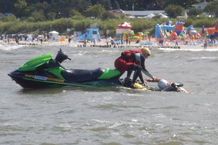 Skuter na wodach Morza Bałtyckiego, ratownik pomaga wyjść z wody osobie poszkodowanej