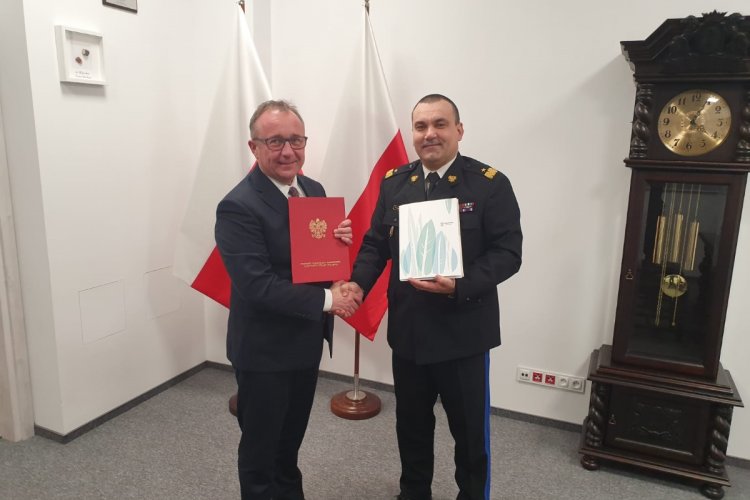Sygnatariusze listu intencyjnego: prezes WFOŚiGW w Gdańsku Maciej Kazienko oraz nadbryg. Tomasz Komoszyński – pomorski komendant wojewódzki PSP; mężczyźni trzymają w rękach teczki z listem intencyjnym, za nimi stoi flaga narodowa 