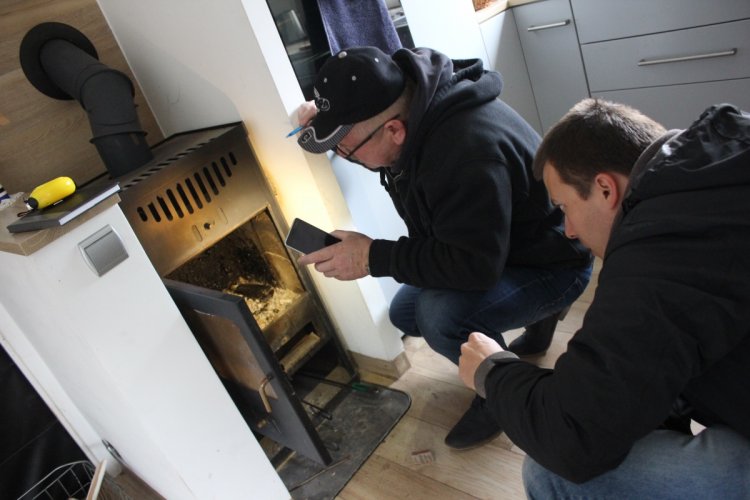 Przegląd serwisowy w ramach programu pilotażowego „Piecodoradcy”, dwóch mężczyzn bada domowy kocioł