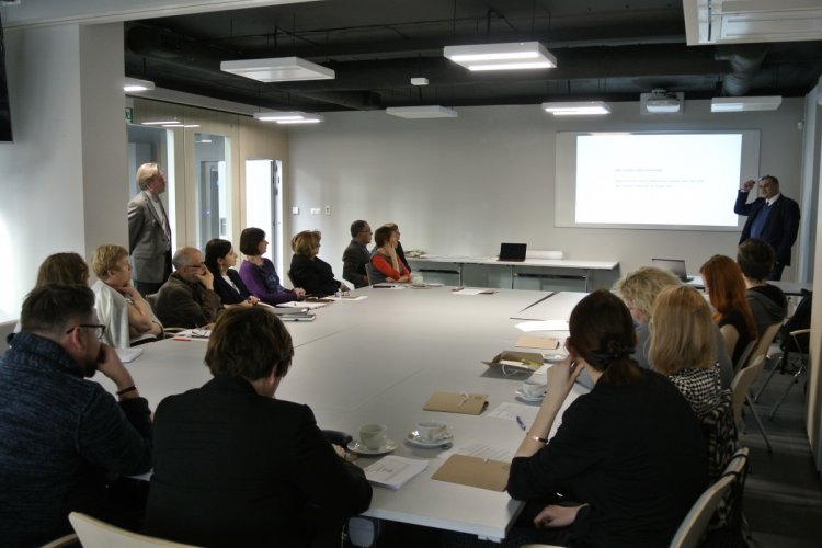 Uczestnicy konferencji „Eco-transformers 2028. Wyzwania dla edukacji w kształtowaniu postaw środowiskowych w XXI wieku” siedzą za stołami i słuchają wykładowcy