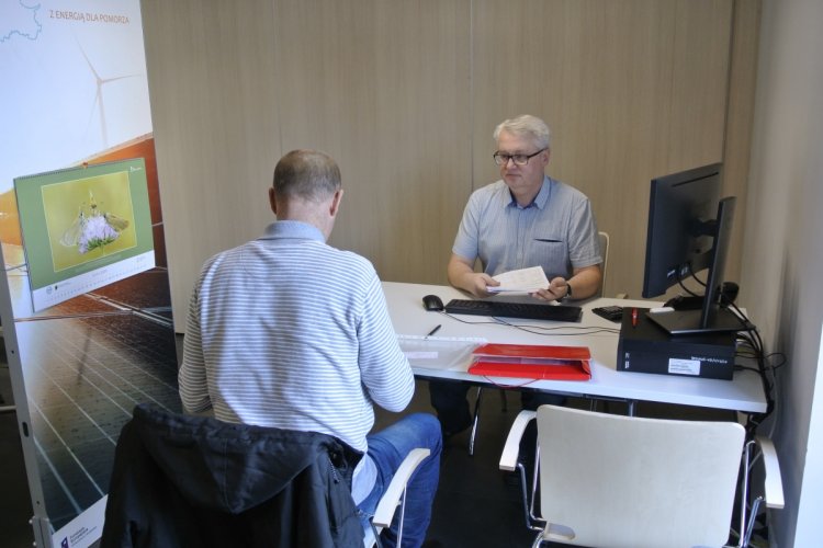 Punkt konsultacyjny w WFOŚiGW w Gdańsku, przy stole siedzą dwie osoby 